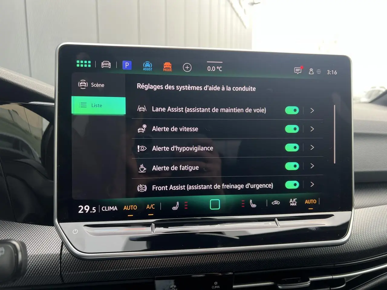 Écran tactile central affichant les réglages d’aide à la conduite dans une Volkswagen Golf VIII noire.