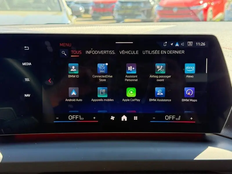 Écran tactile central de la BMW Série 1 120dA M Sport 2025 affichant les applications connectées, vue intérieure frontale.