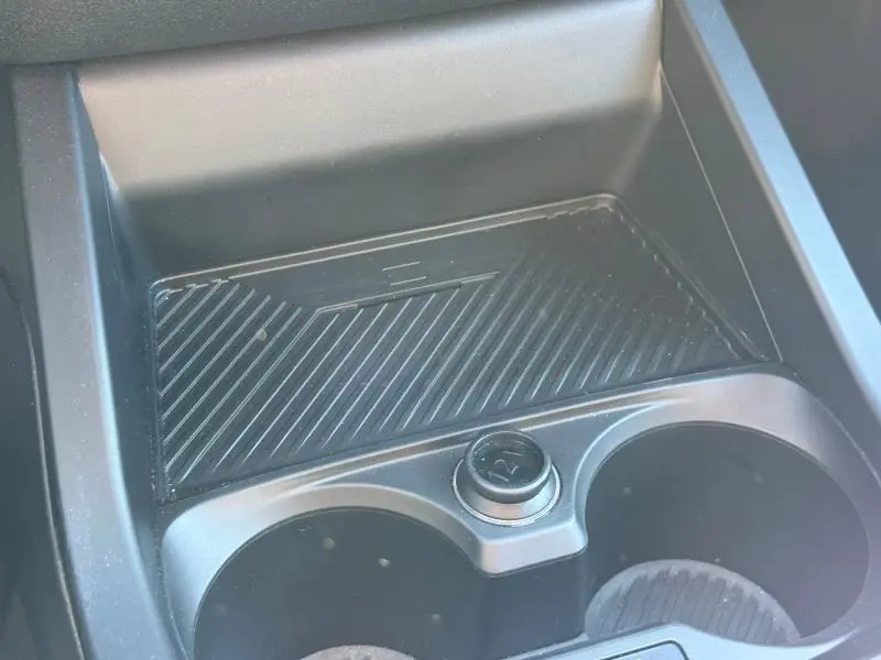 Gros plan sur la console centrale noire avec porte-gobelets et prise 12V de la BMW Série 1 M Sport 120dA.