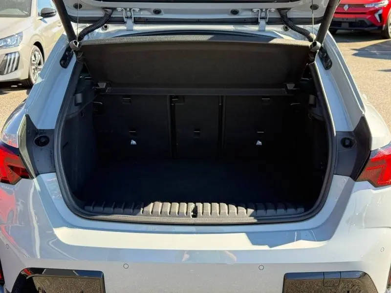 Coffre ouvert vu de l'arrière d'une BMW Série 1 120dA M Sport blanc Alpinweiss, espace de chargement vide.