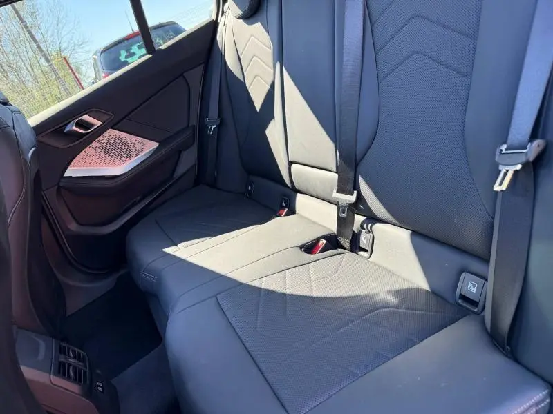 Vue intérieure arrière côté gauche de la BMW Série 1 120dA M Sport avec sièges sport en Alcantara noir et inserts métal.