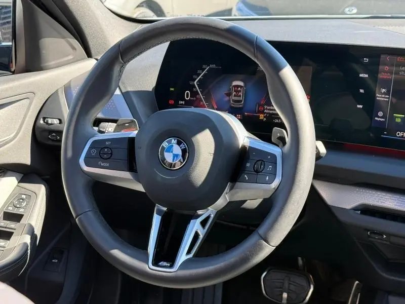 Vue rapprochée du volant cuir multifonction et du tableau de bord numérique de la BMW Série 1 M Brooklyn Grey 2025.