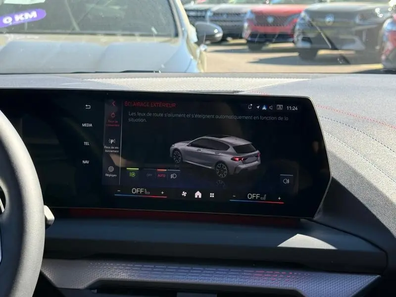 Écran central affichant une BMW Série 1 120dA M Sport en vue 3/4 arrière, couleur gris Brooklyn métallisé.