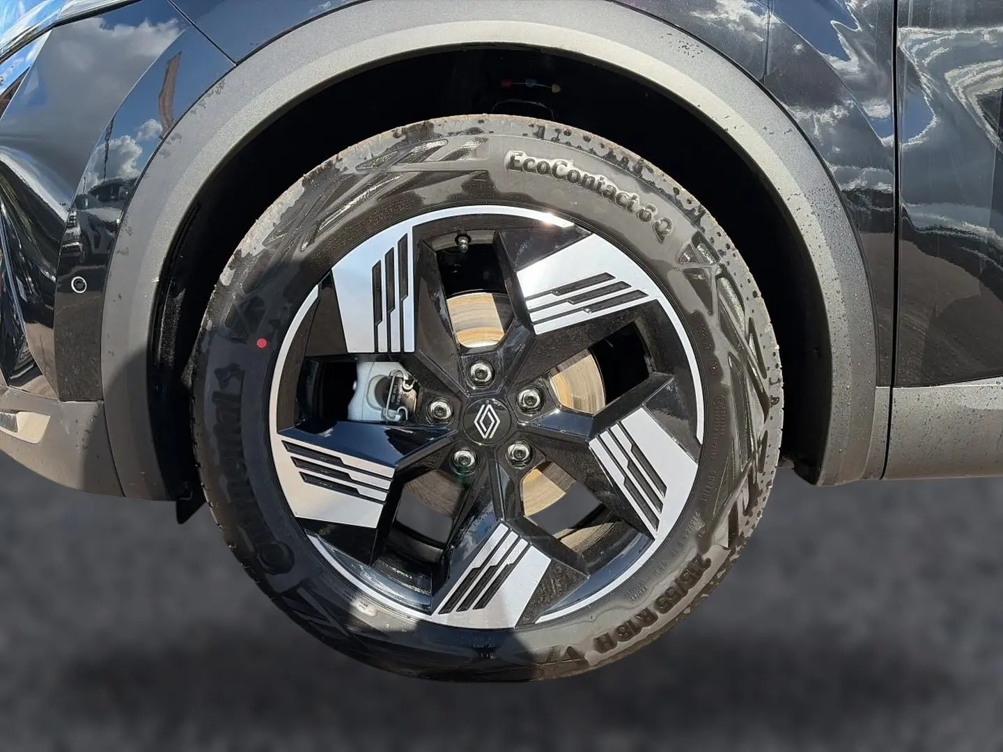 Gros plan sur la roue avant gauche noire étoile d'une Renault Symbioz 1.8 e-tech avec jante alu à design géométrique.