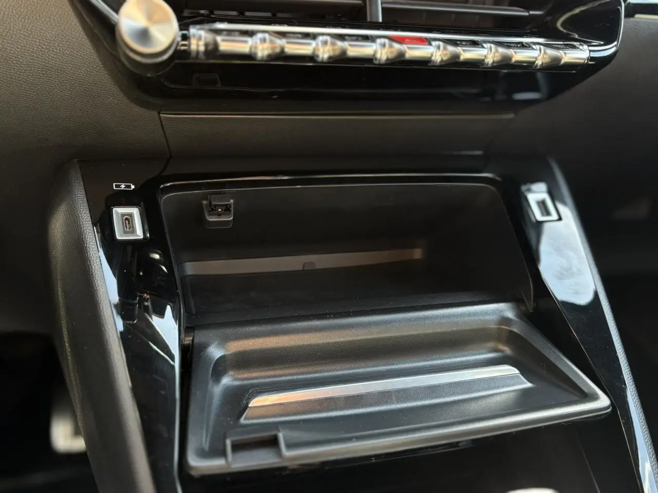 Vue rapprochée de la console centrale noire du Peugeot 2008 GT 2021 avec ports USB et commandes chromées.
