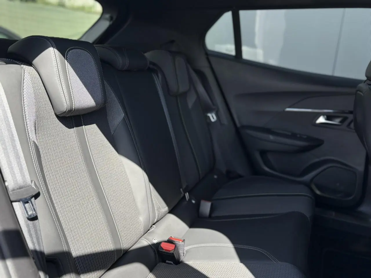 Vue latérale droite de l’habitacle arrière du Peugeot 2008 1.5 BlueHDI GT, sièges noirs et garnitures tissu/TEP.