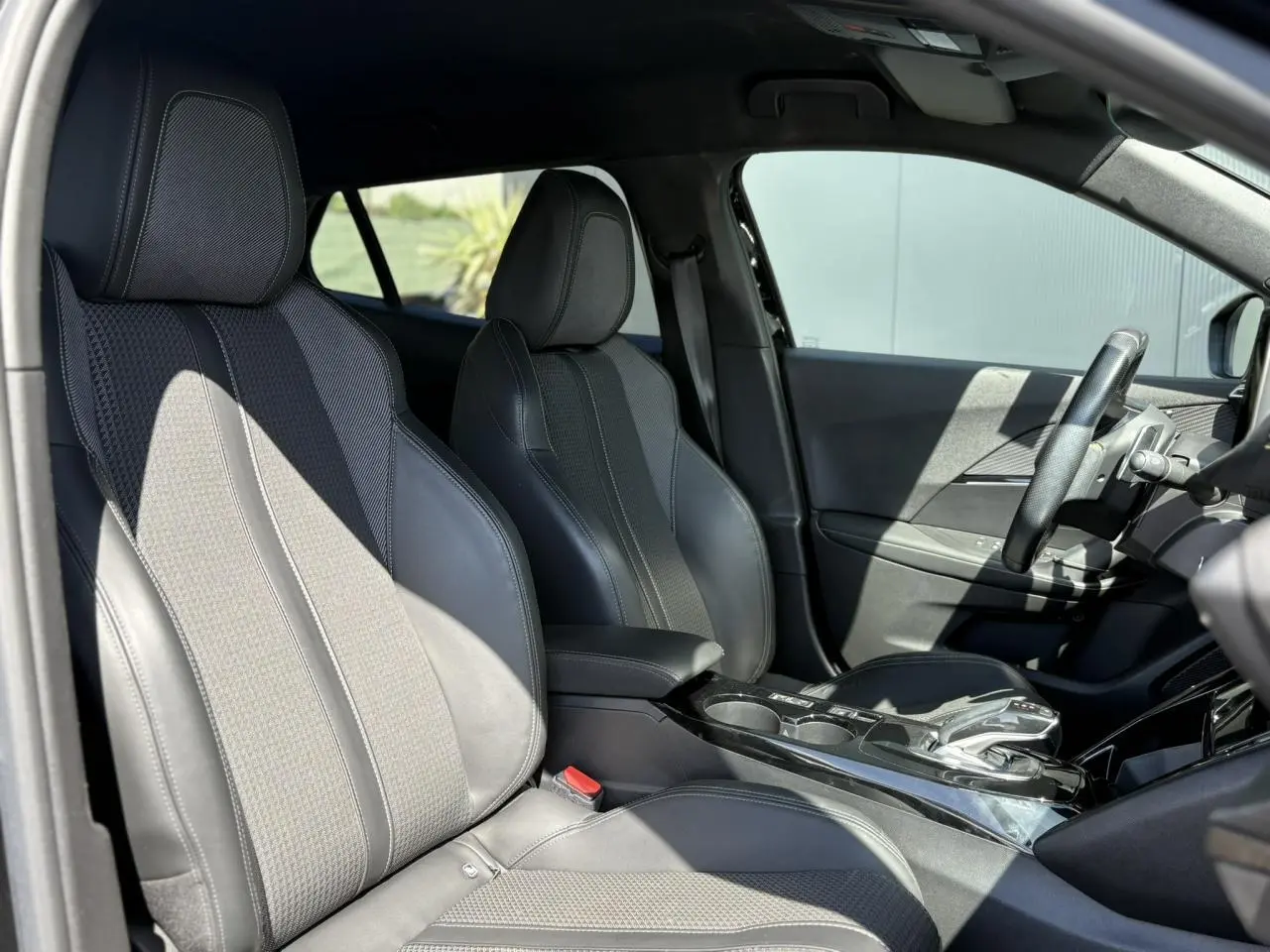 Vue intérieure côté gauche montrant les sièges avant en tissu et cuir noir du Peugeot 2008 GT 2021.