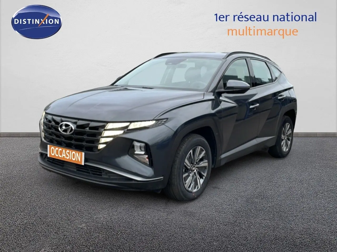 Vue 3/4 avant d'un Hyundai Tucson 2023 hybride en Dark Knight Metal avec calandre distinctive et jantes alliage.