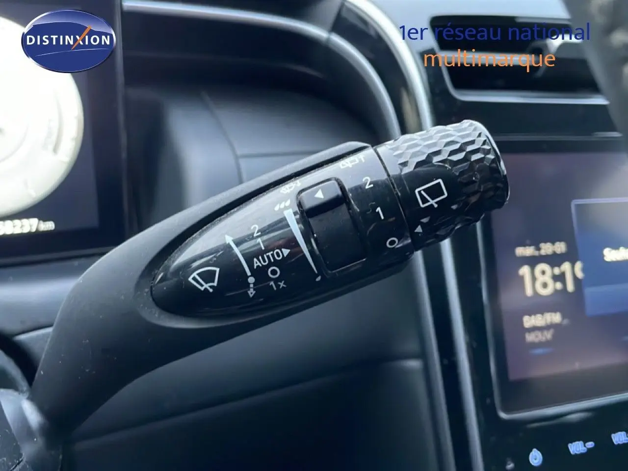 Gros plan sur la commande d’essuie-glace du Hyundai Tucson 2023, avec détails des réglages et tableau de bord en arrière-plan.