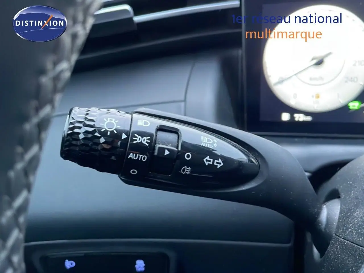 Gros plan sur la commande des phares et clignotants à gauche du volant dans l’habitacle du Hyundai Tucson 2023 couleur Dark Knight Metal.
