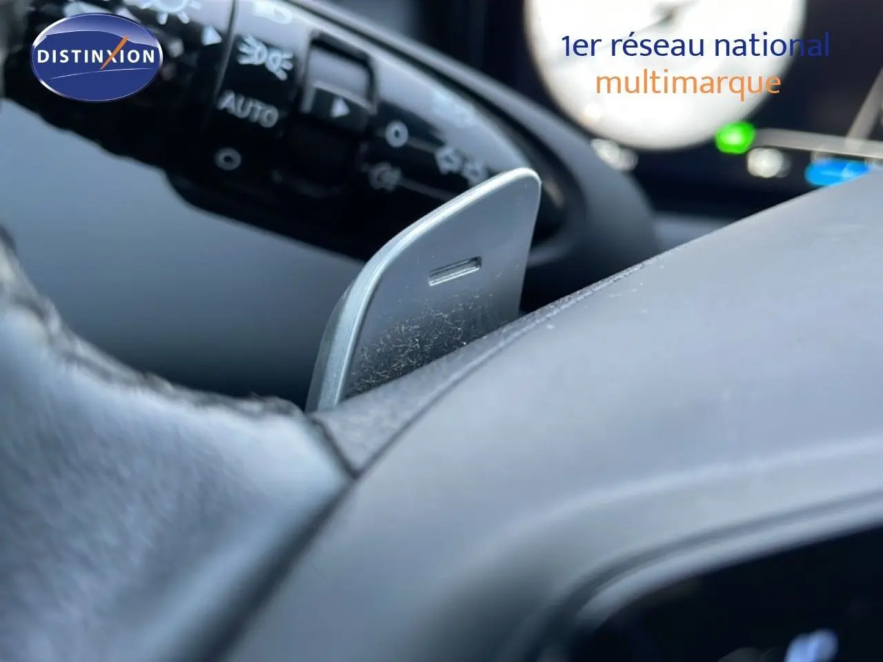 Détail d'une palette de changement de vitesse grise sur le volant noir d'un Hyundai Tucson hybride 2023.
