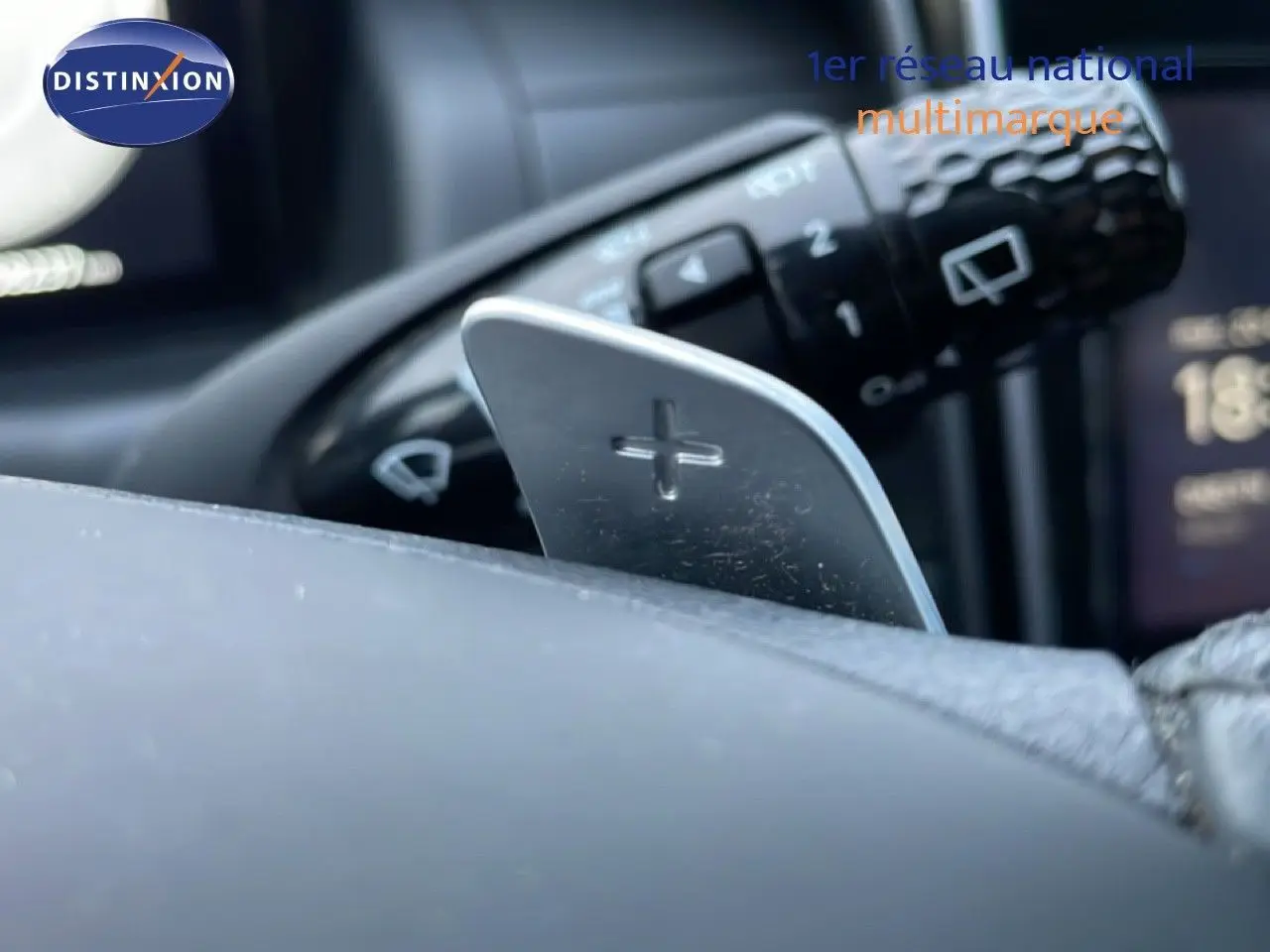 Gros plan sur la palette de changement de vitesse "+" côté droit du volant du Hyundai Tucson 2023 hybride.