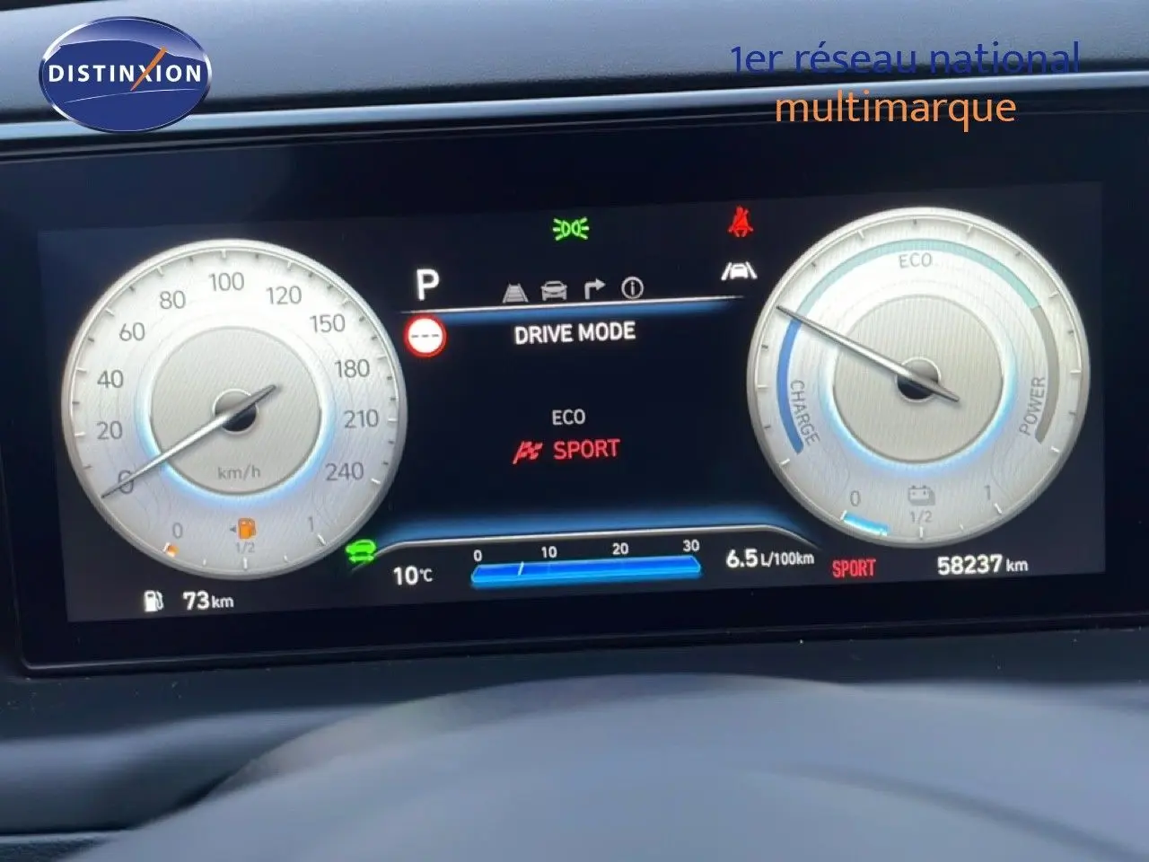 Vue rapprochée du tableau de bord numérique du Hyundai Tucson 2023, affichant les modes de conduite et la consommation.