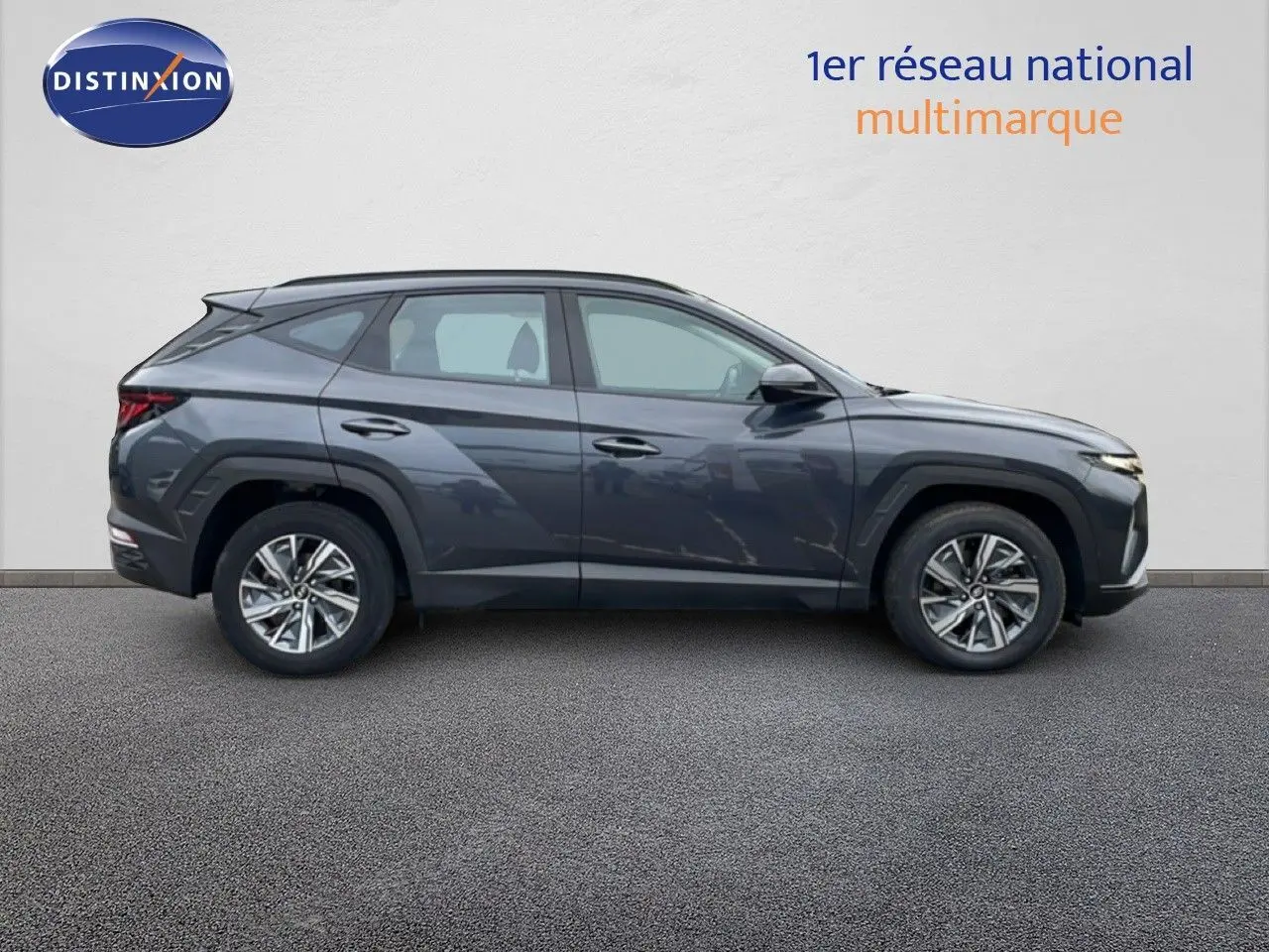 Vue de profil droit du Hyundai Tucson 2023 hybride en finition Business, couleur Dark Knight Metal avec jantes alliage.