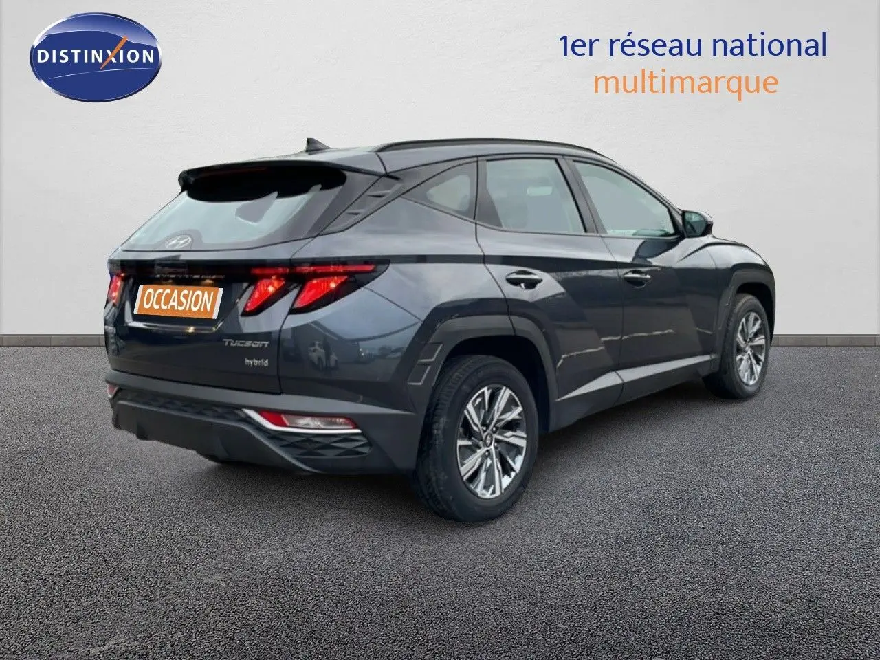 Vue 3/4 arrière droite d'un Hyundai Tucson 2023 hybride en couleur Dark Knight Metal avec feux arrière LED distinctifs.