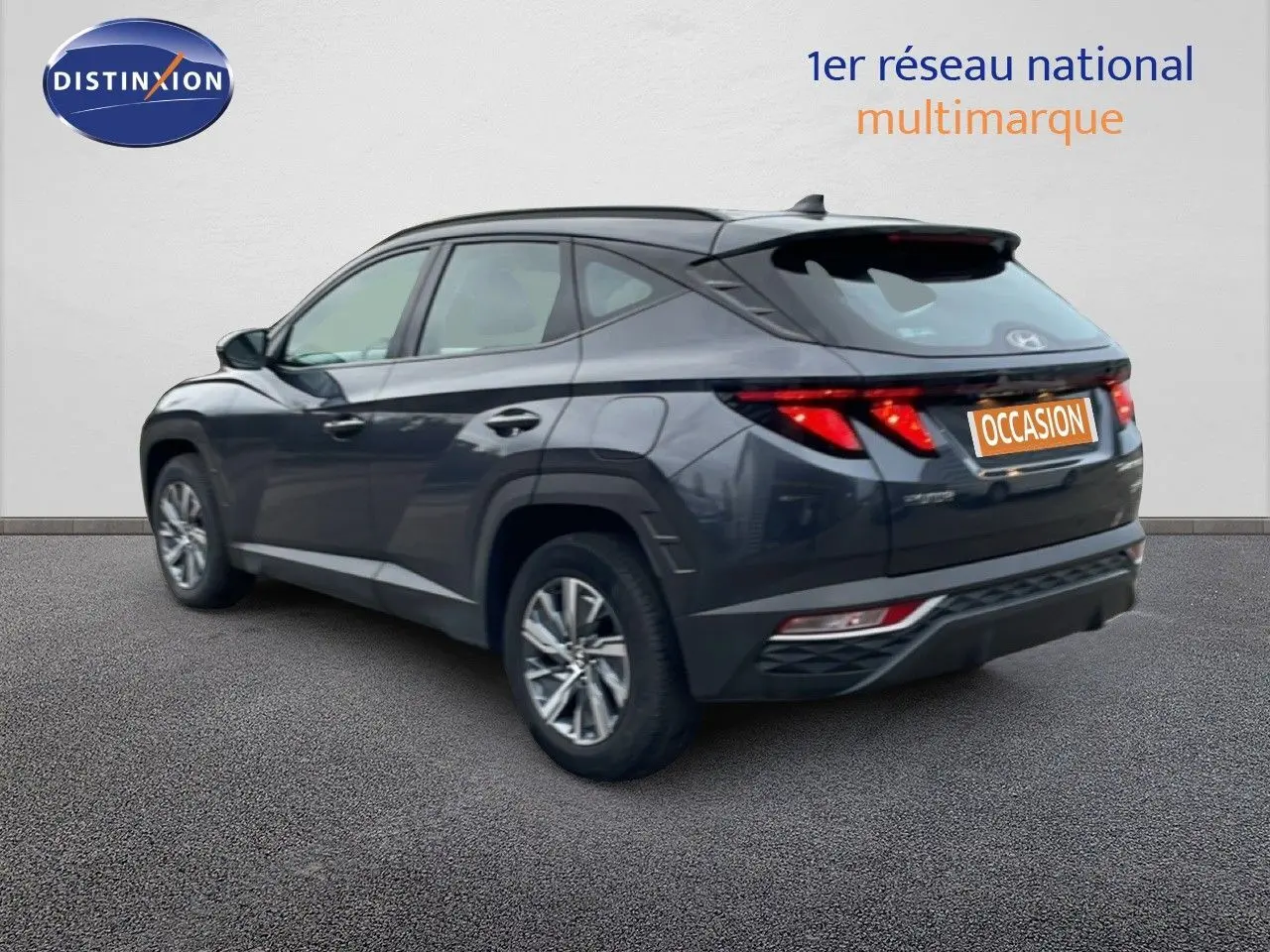 Vue 3/4 arrière droite d'un Hyundai Tucson 2023 hybride en gris foncé Dark Knight Metal avec feux arrière LED distinctifs.