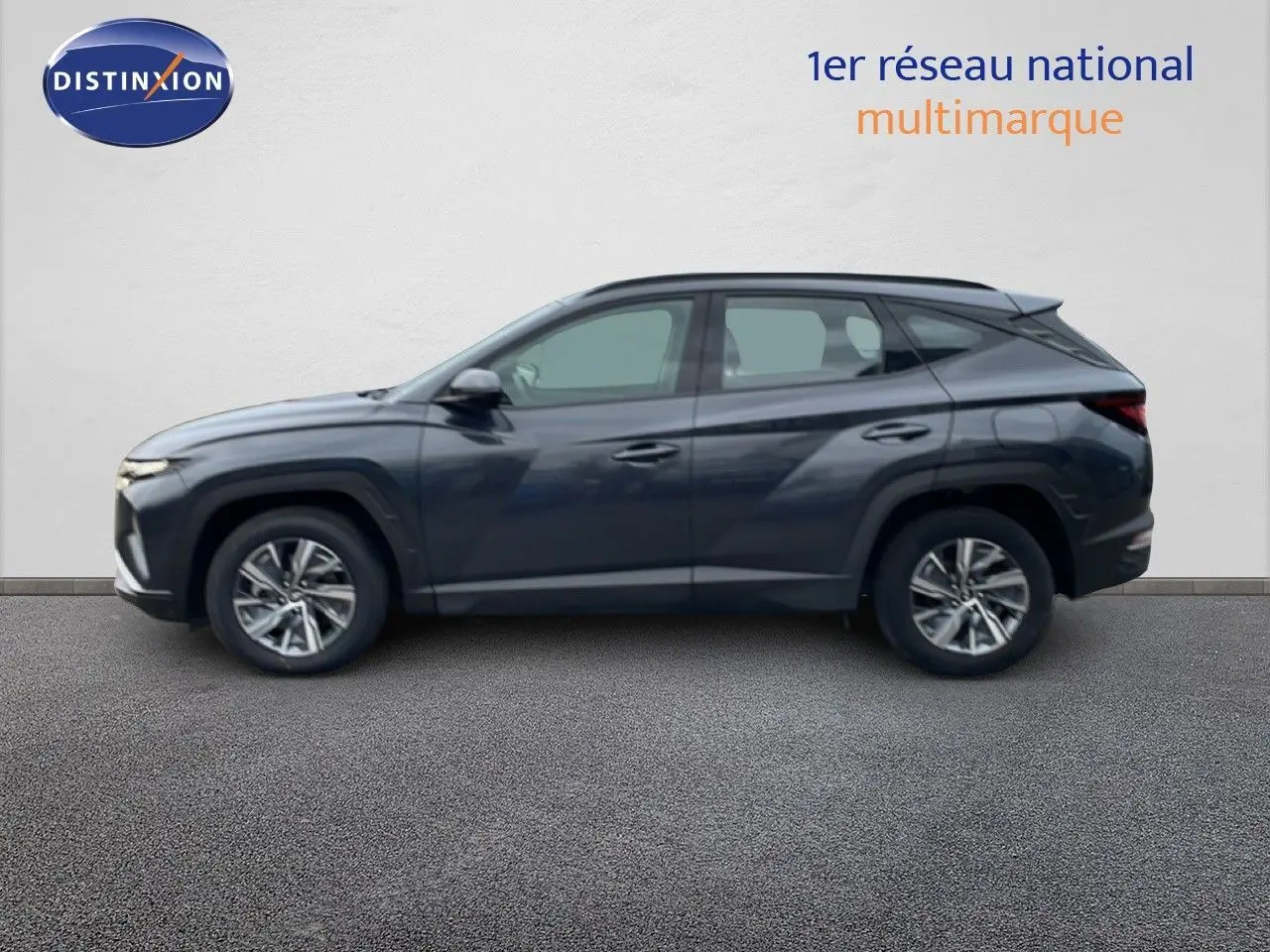 Vue de profil côté gauche d'un Hyundai Tucson 2023 hybride en couleur Dark Knight Metal, avec jantes alliage et lignes anguleuses.