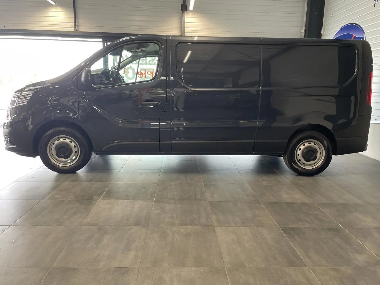 Vue de profil côté gauche du Renault Trafic Fourgon gris Comète avec jantes tôles et porte coulissante visible.
