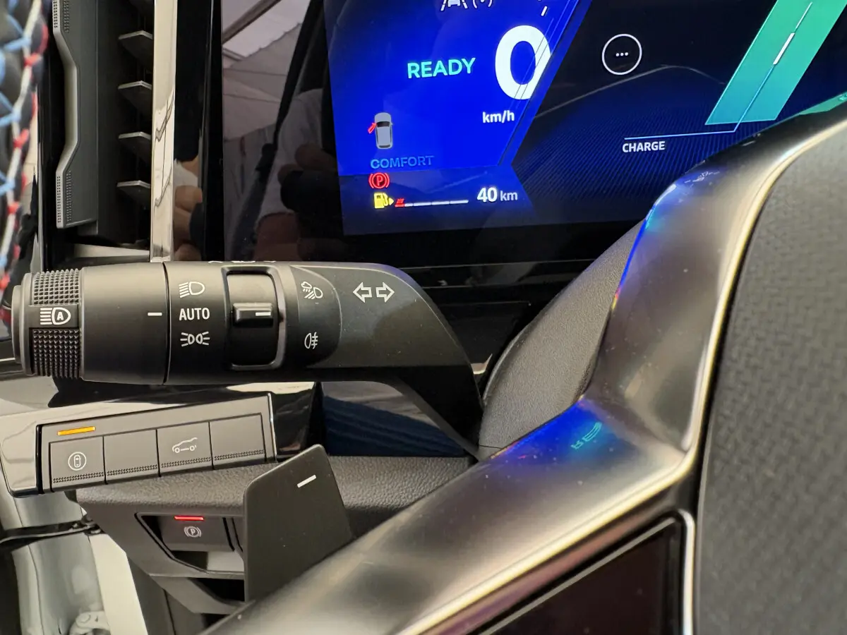 Gros plan sur la commande des feux et clignotants à gauche du volant dans un Renault Espace blanc 2025 esprit Alpine.