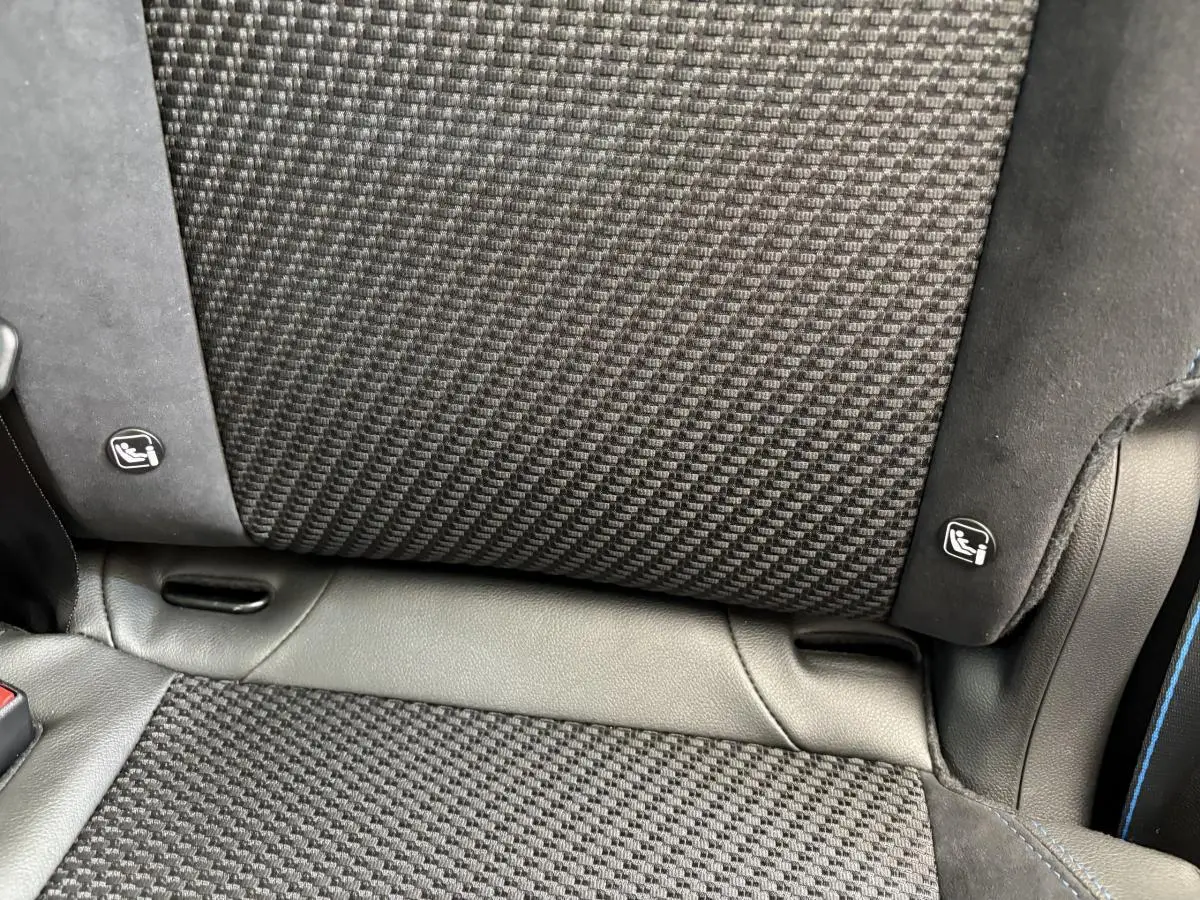 Gros plan sur le tissu et cuir noir du siège arrière avec indication Isofix sur Renault Espace Esprit Alpine blanc.