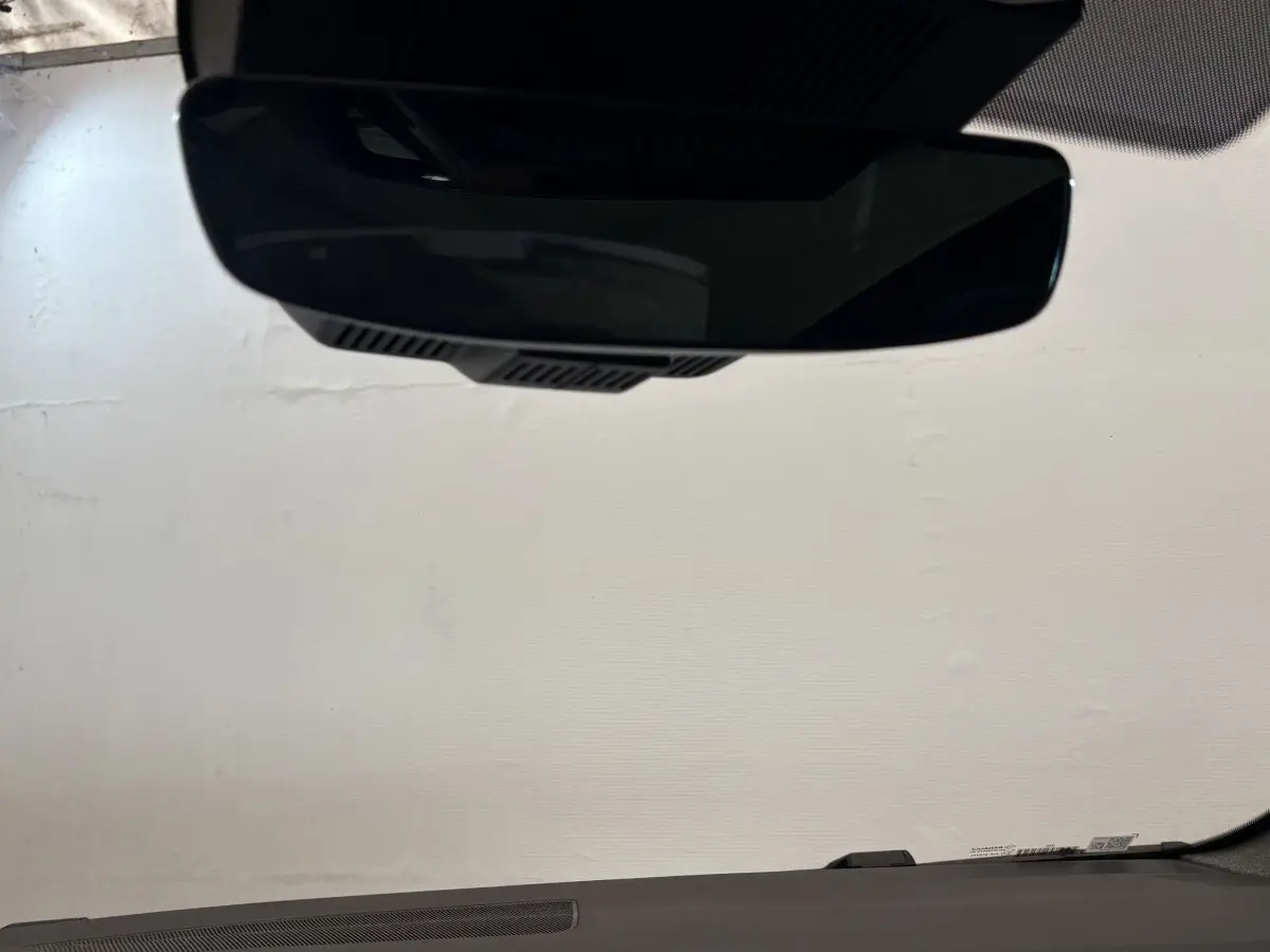 Vue intérieure du rétroviseur central d'un Renault Espace blanc 2025, avec tableau de bord sombre en arrière-plan.