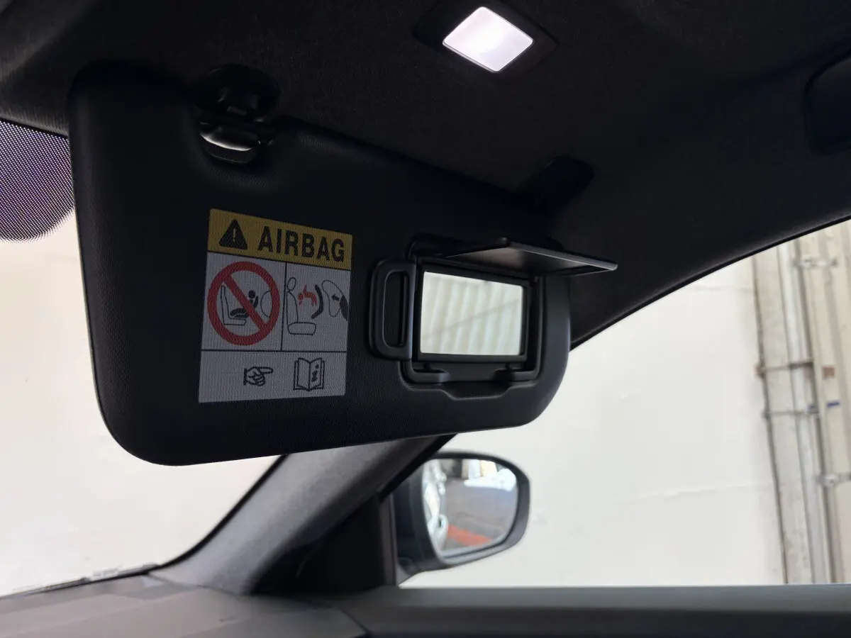 Miroir de courtoisie ouvert sur pare-soleil côté conducteur dans l'habitacle sombre du Renault Espace blanc 2025.