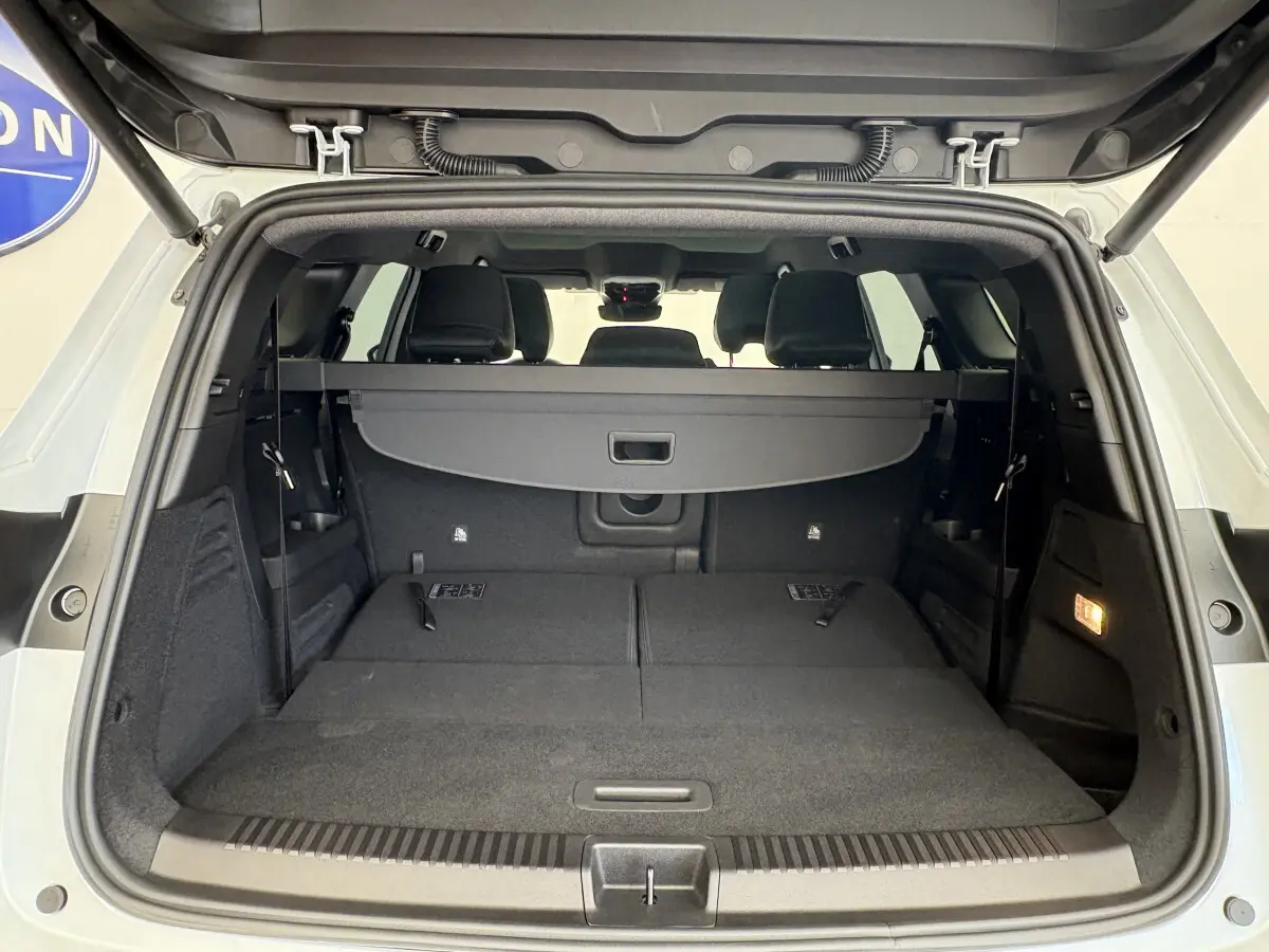 Coffre ouvert d’un Renault Espace blanc 2025, vue arrière montrant banquette arrière rabattue et plancher plat noir.