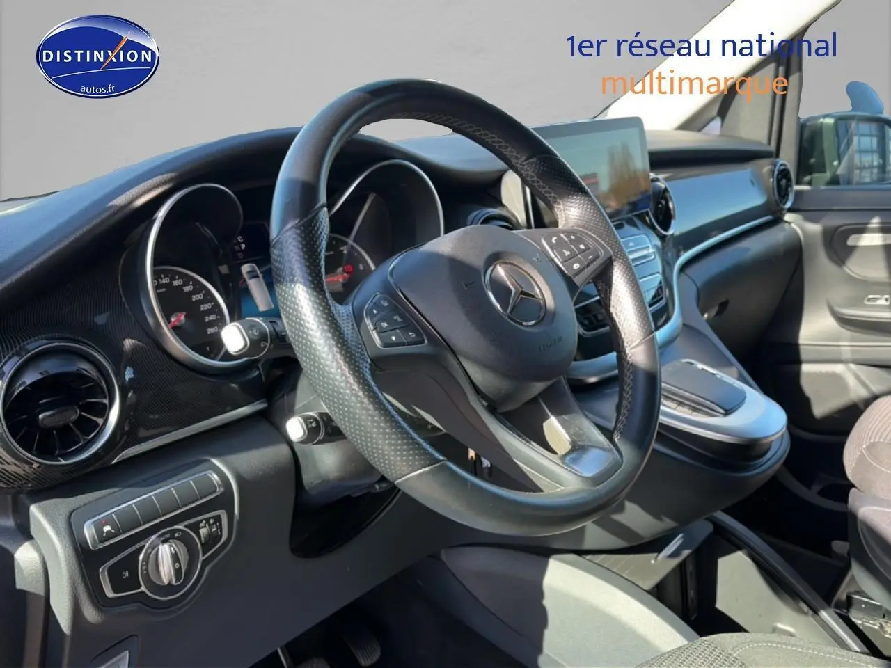 Vue intérieure de face du poste de conduite noir du Mercedes Classe V 220 d long style avec volant multifonction.
