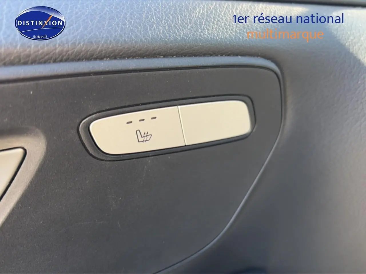 Détail du bouton de siège chauffant sur la porte intérieure d’un Mercedes Classe V noir 220 d long style 2021.