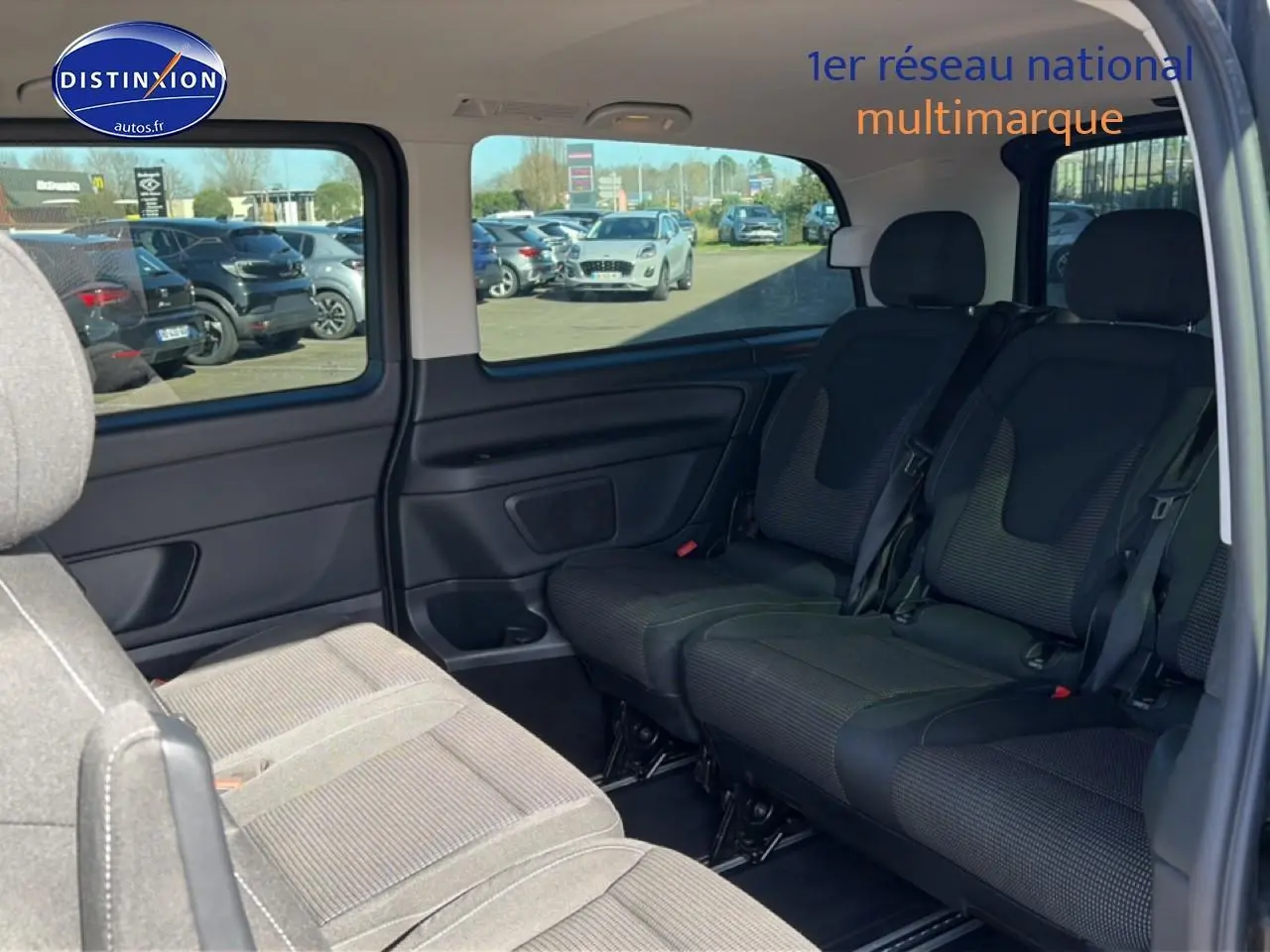Vue intérieure sur les sièges arrière en tissu noir du Mercedes Classe V 220 d long style, avec porte latérale coulissante ouverte.
