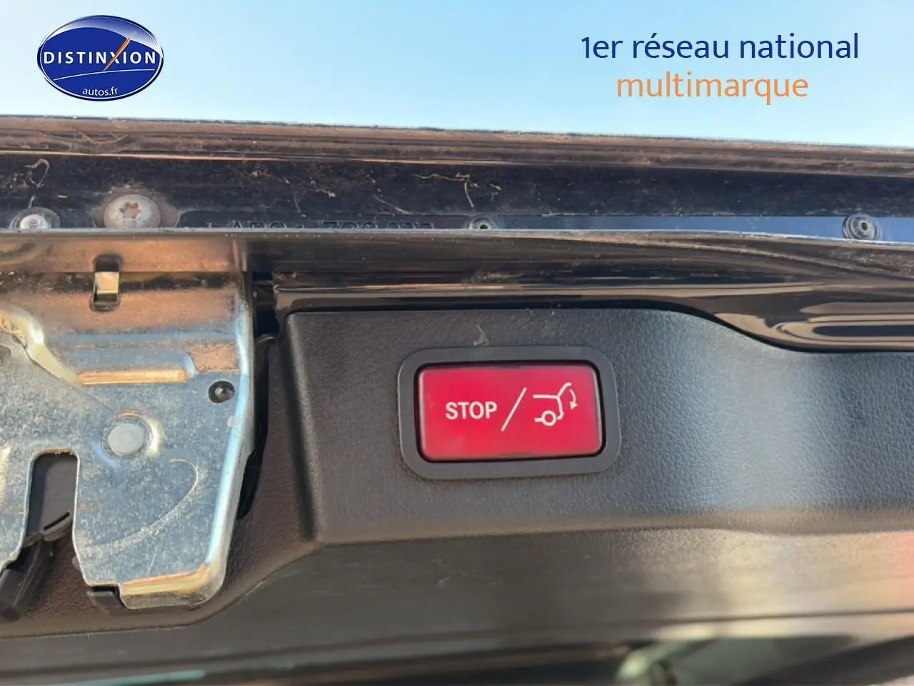 Gros plan sur le bouton rouge stop du hayon électrique du Mercedes Classe V noir, vue intérieure du coffre ouvert.