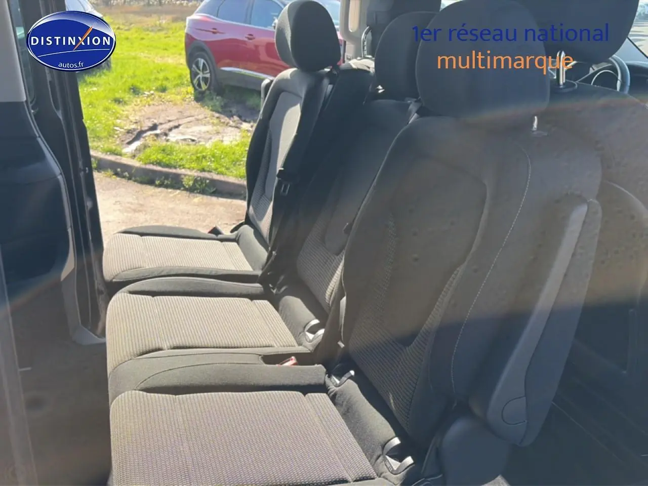 Vue intérieure sur les sièges arrière en tissu noir du Mercedes Classe V 220 d long, porte latérale coulissante ouverte.