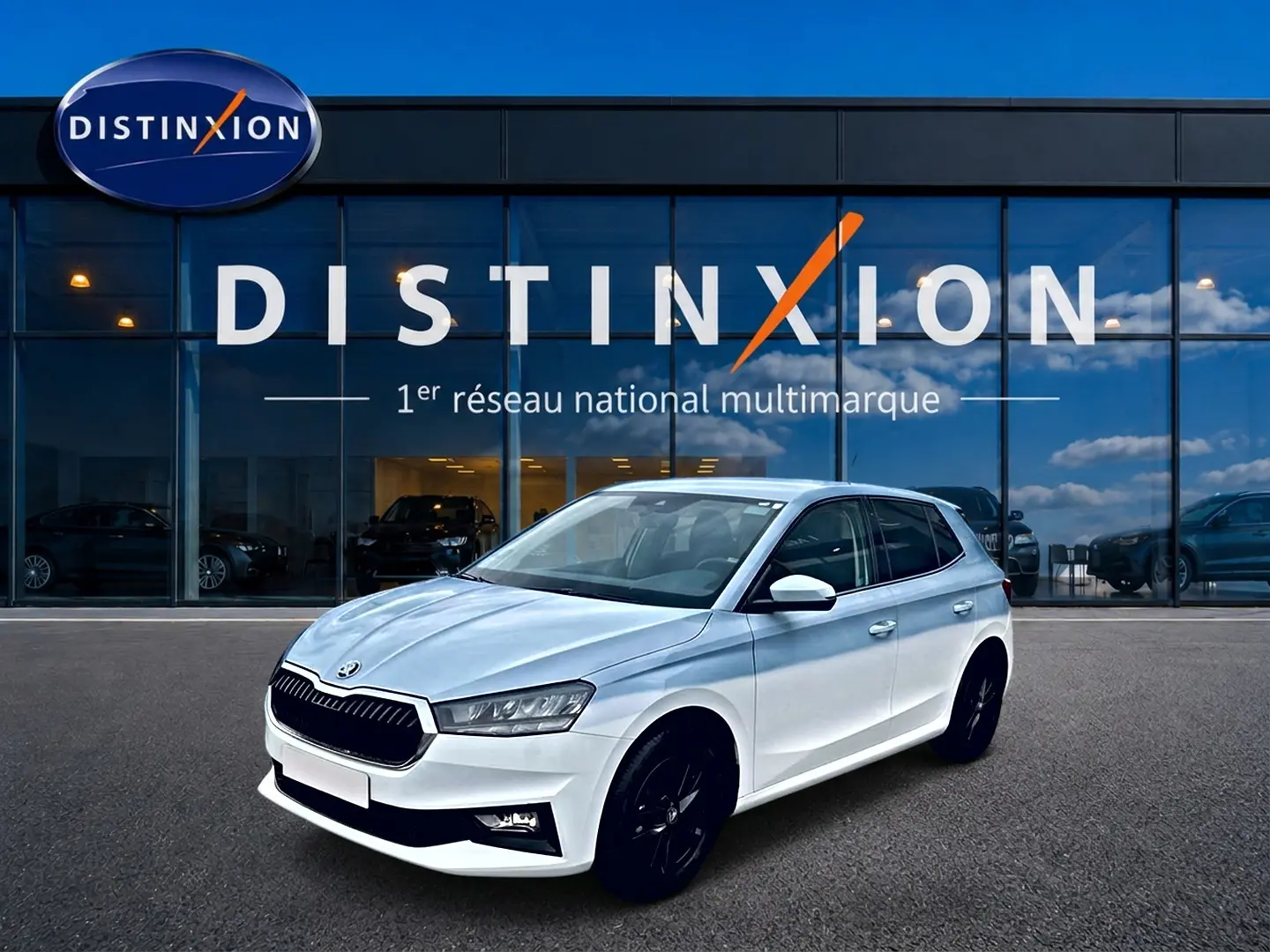 SKODA FABIA blanche vue 3/4 avant droit avec jantes noires devant vitrine Distinxion.