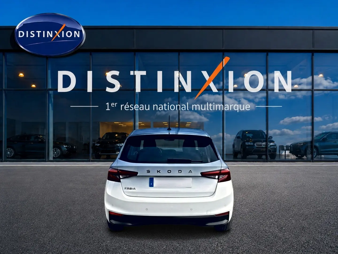 Vue arrière d'une Skoda Fabia blanche 2025 garée devant une vitrine avec logo Distinxion.