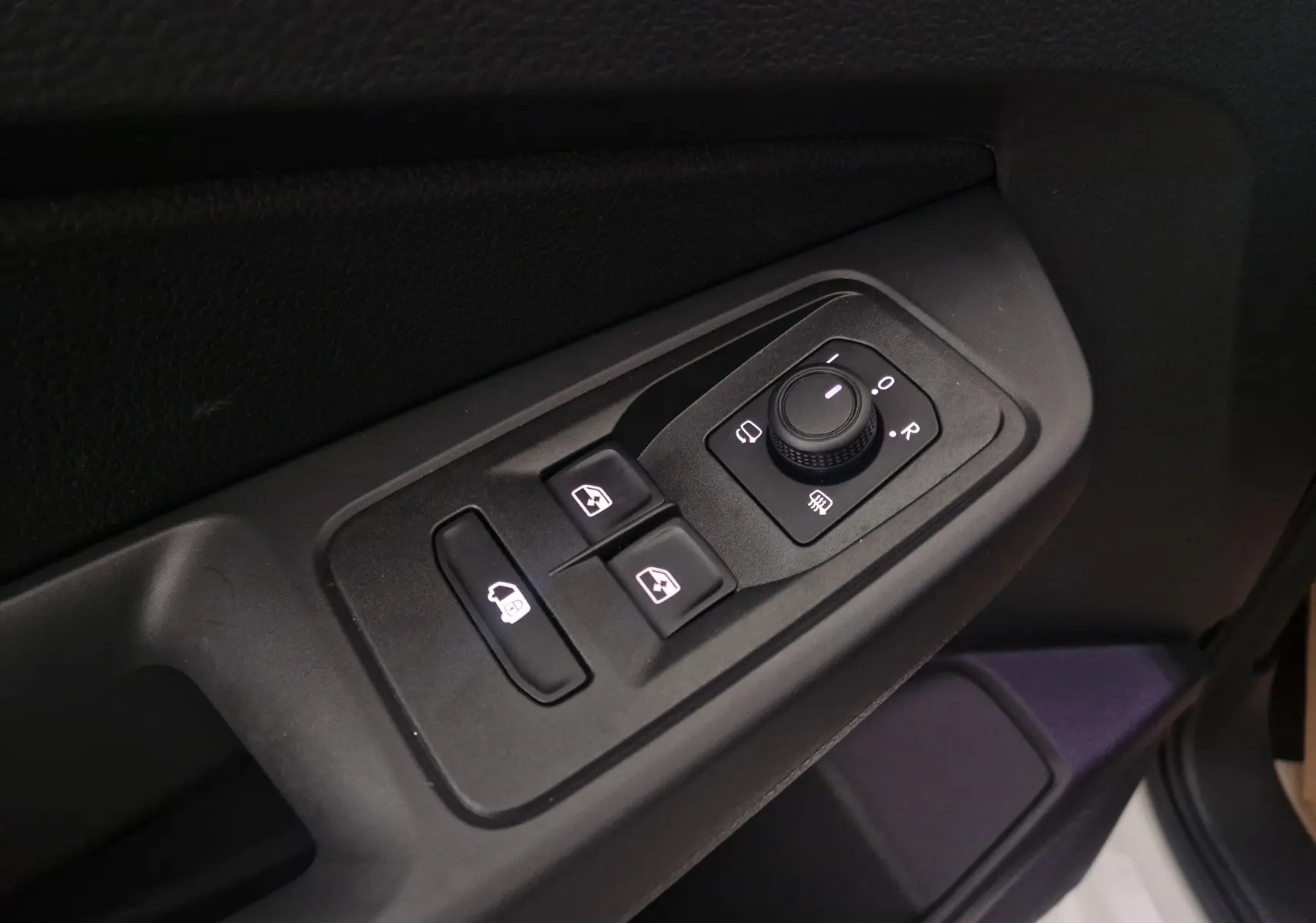 Gros plan sur les commandes de réglage des rétroviseurs et des vitres côté conducteur du Volkswagen Caddy Maxi blanc 2025.