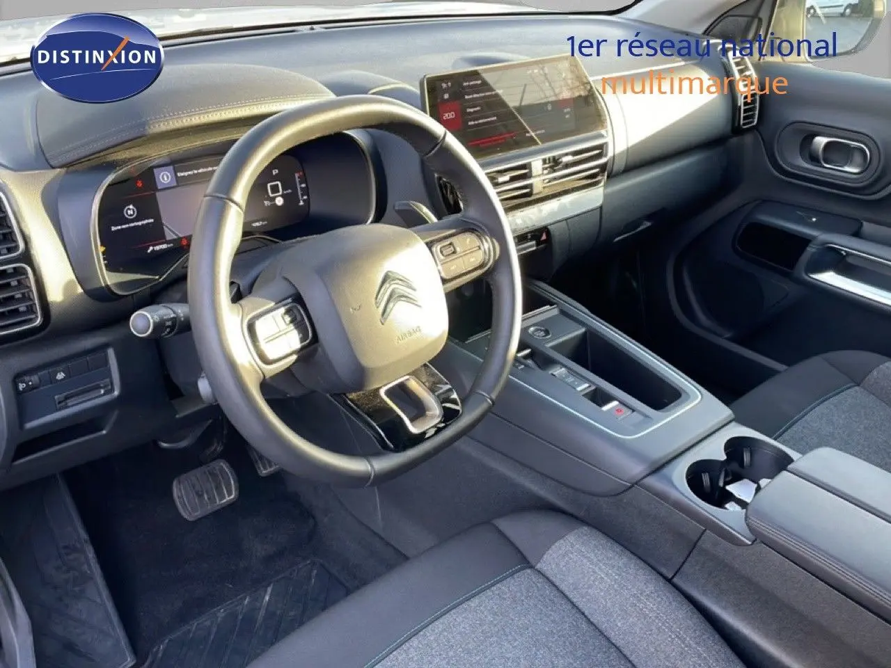 Vue intérieure côté conducteur du Citroën C5 Aircross 2025, tableau de bord moderne avec écran tactile et volant multifonction noir.