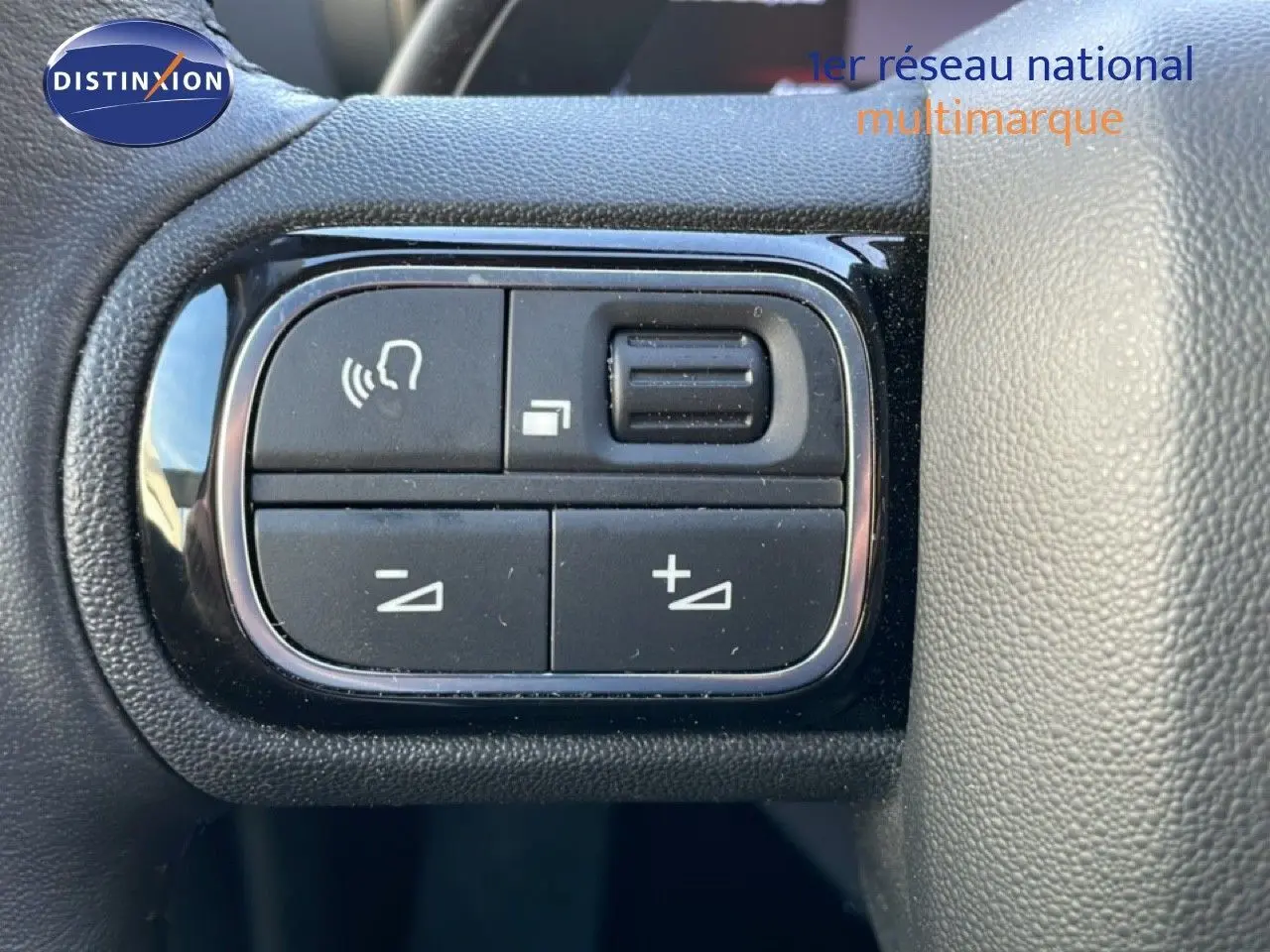 Gros plan sur les commandes de réglage vocal et volume au volant du Citroën C5 Aircross 2025 blanc Okenite Metal.