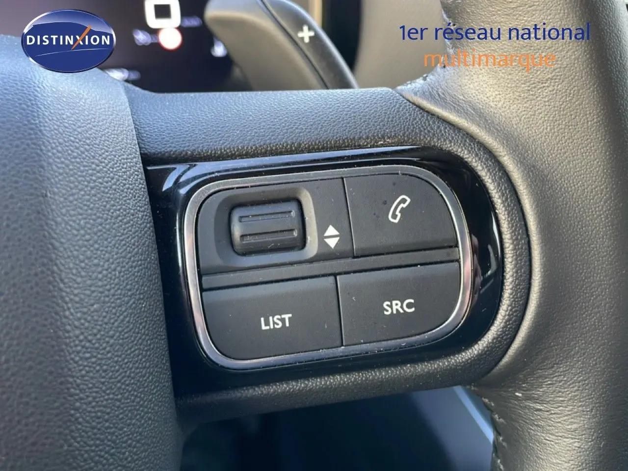 Gros plan sur les commandes au volant du Citroën C5 Aircross 2025, finition tissu noir, avec boutons de gestion audio et appel.