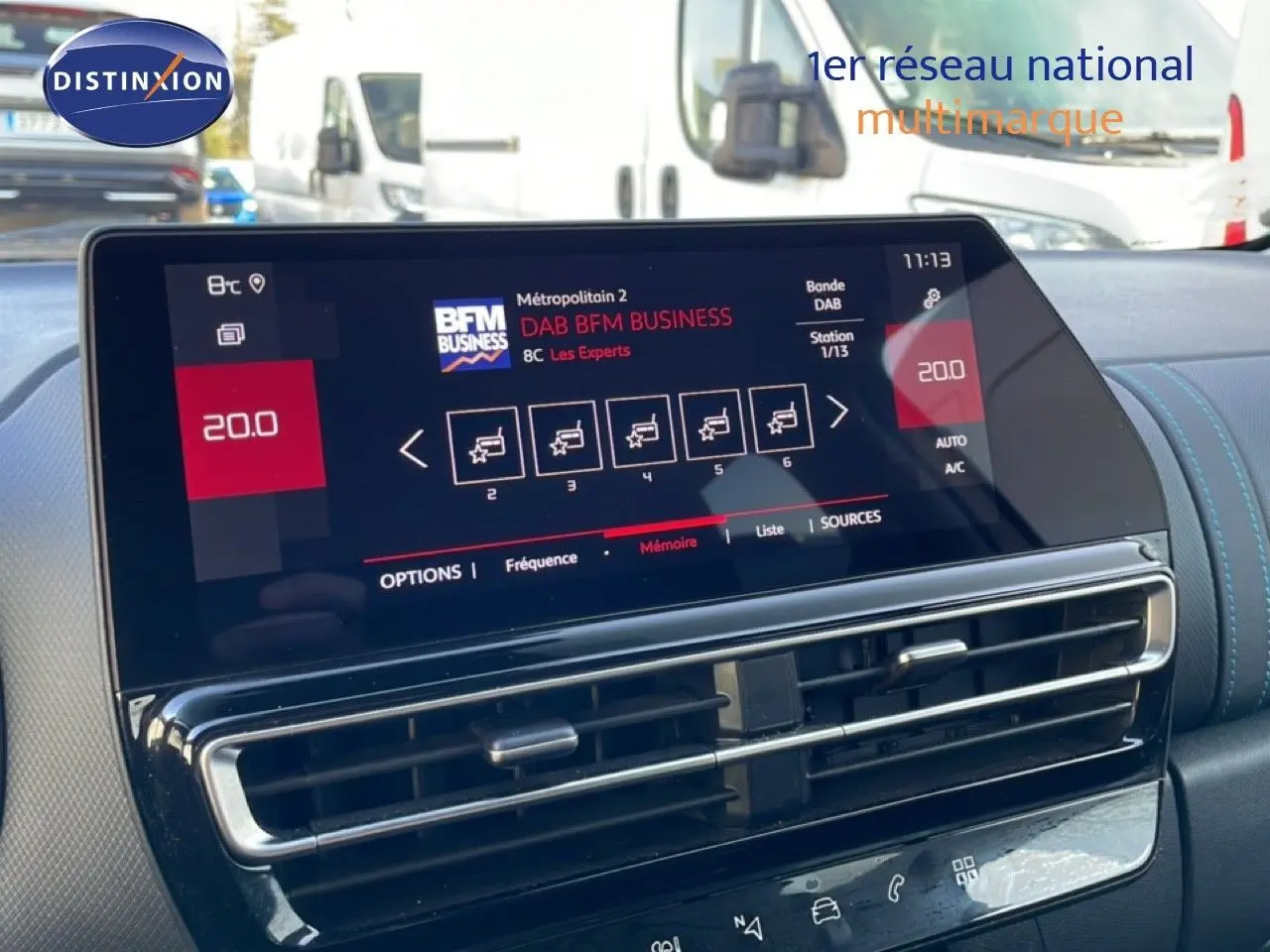 Vue intérieure centrée sur l'écran tactile du tableau de bord du Citroën C5 Aircross blanc, affichant la radio numérique.