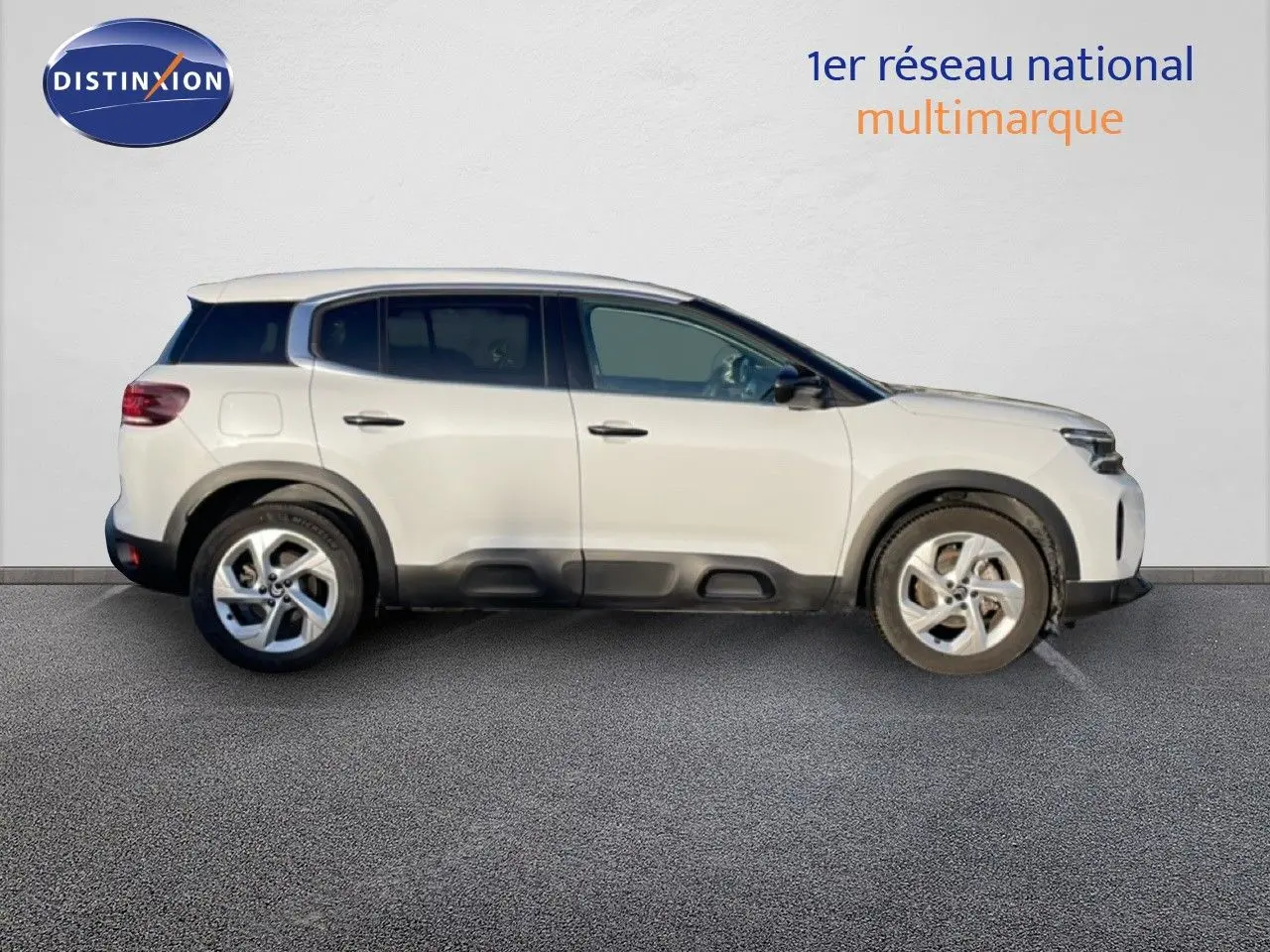 Vue de profil côté gauche d'un Citroën C5 Aircross blanc Okenite avec jantes alliage et protections noires basses.