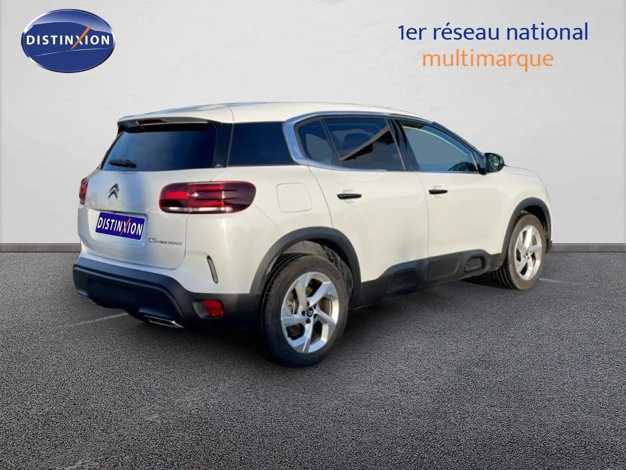 Vue 3/4 arrière droite d'un Citroën C5 Aircross blanc Okenite avec jantes alliage et vitres teintées.