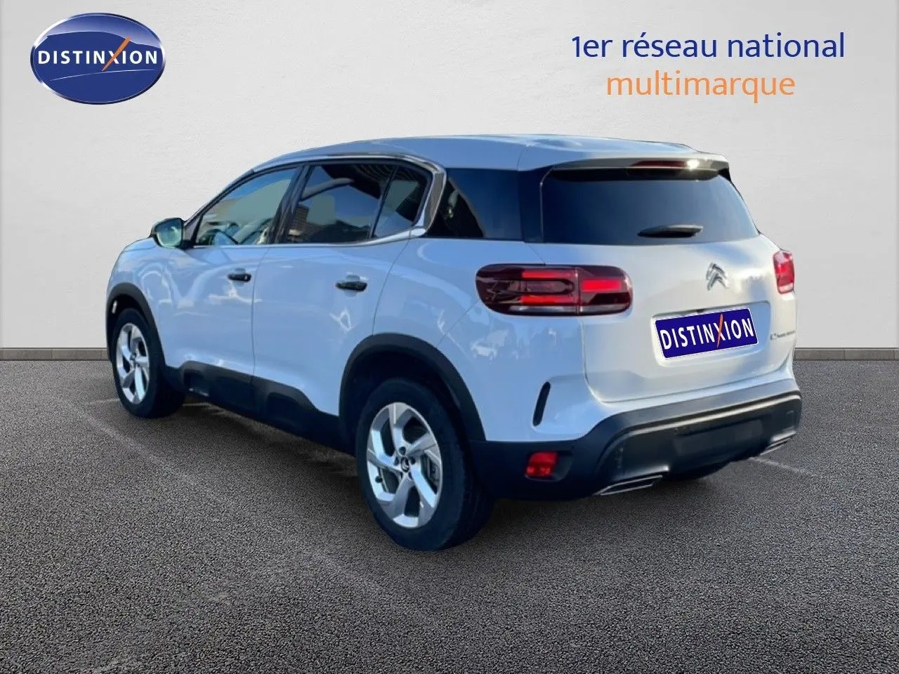 Vue 3/4 arrière droite d'un Citroën C5 Aircross blanc Okenite Metal avec toit noir et feux arrière LED.