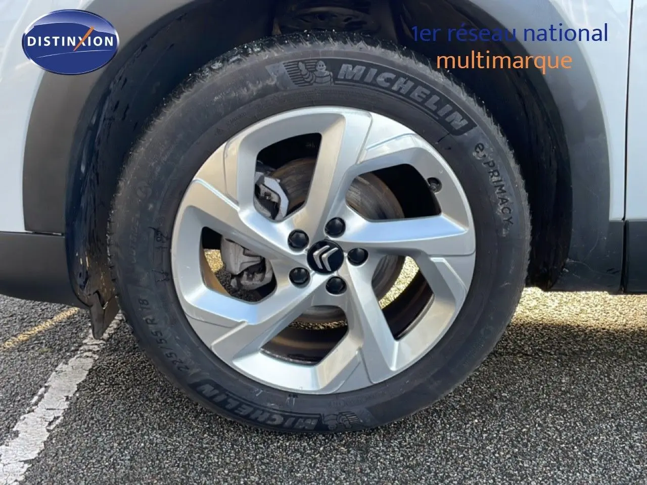 Gros plan sur la roue avant droite d’un Citroën C5 Aircross blanc Okenite avec jante alliage et pneu Michelin.