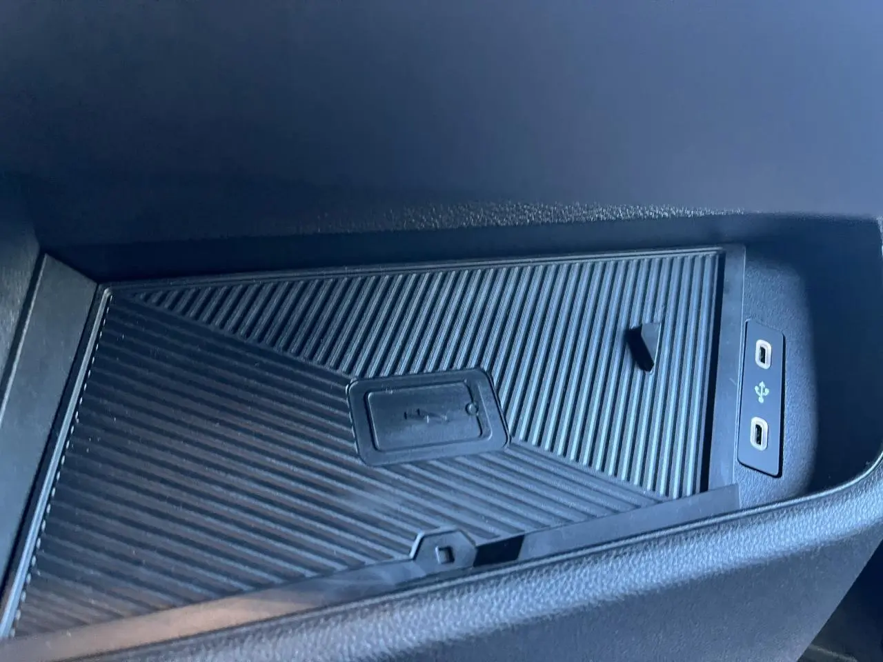 Gros plan sur le chargeur à induction et ports USB dans l'habitacle noir du Renault Master blanc 2025.