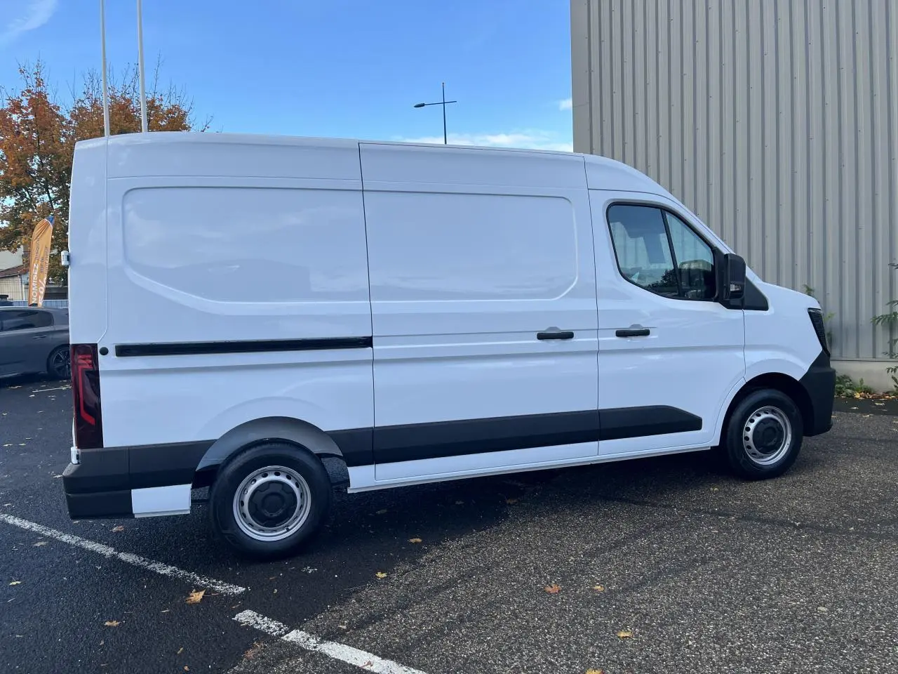Renault Master blanc en vue de profil côté gauche, fourgon utilitaire avec panneaux latéraux tôlés et jantes tôles.