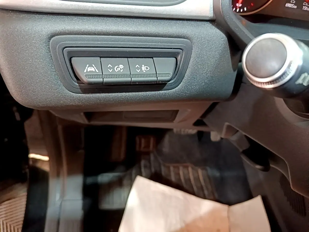 Détail des commandes d'assistance à la conduite sur la gauche du tableau de bord du Renault Captur noir 2021.