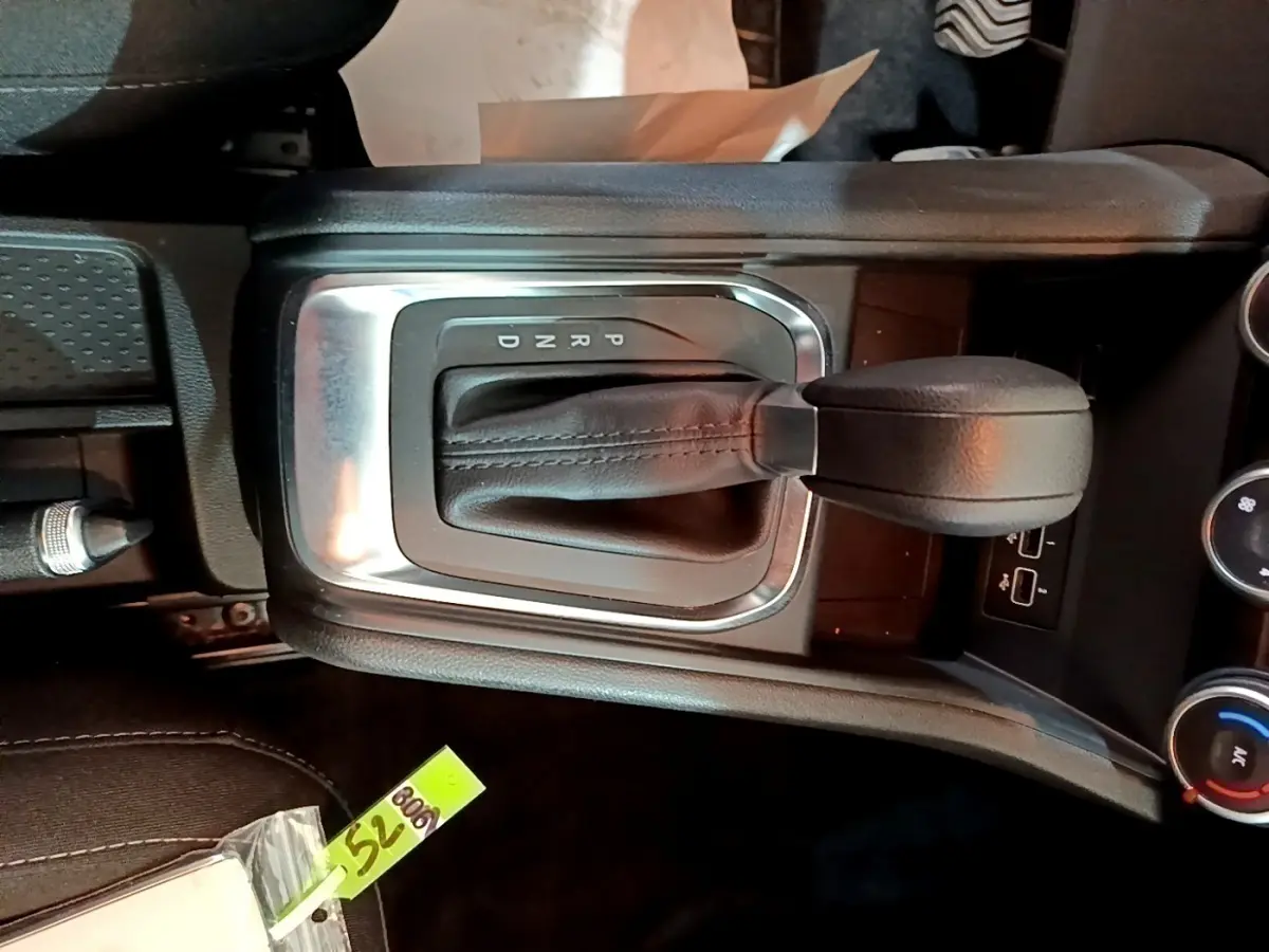 Gros plan sur le levier de vitesse automatique noir du Renault Captur Business TCe 140, entouré de commandes et ports USB.