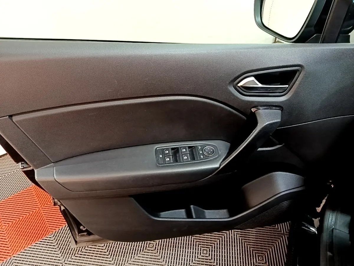 Vue intérieure côté gauche de la porte avant noire du Renault Captur 2021 avec commandes électriques des vitres et poignée intégrée.