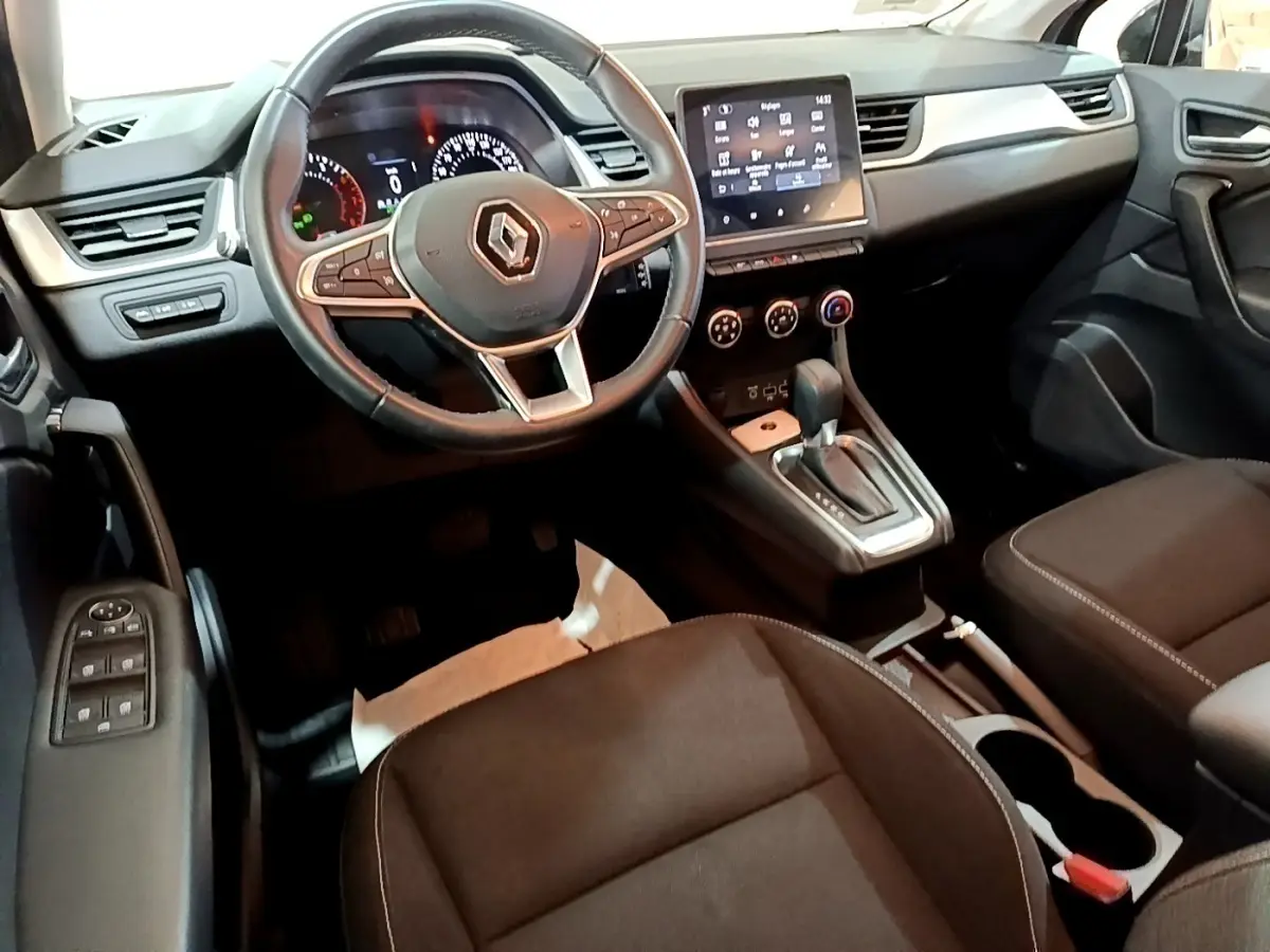 Vue intérieure du poste de conduite du Renault Captur Business noir, avec volant multifonctions et écran tactile central.