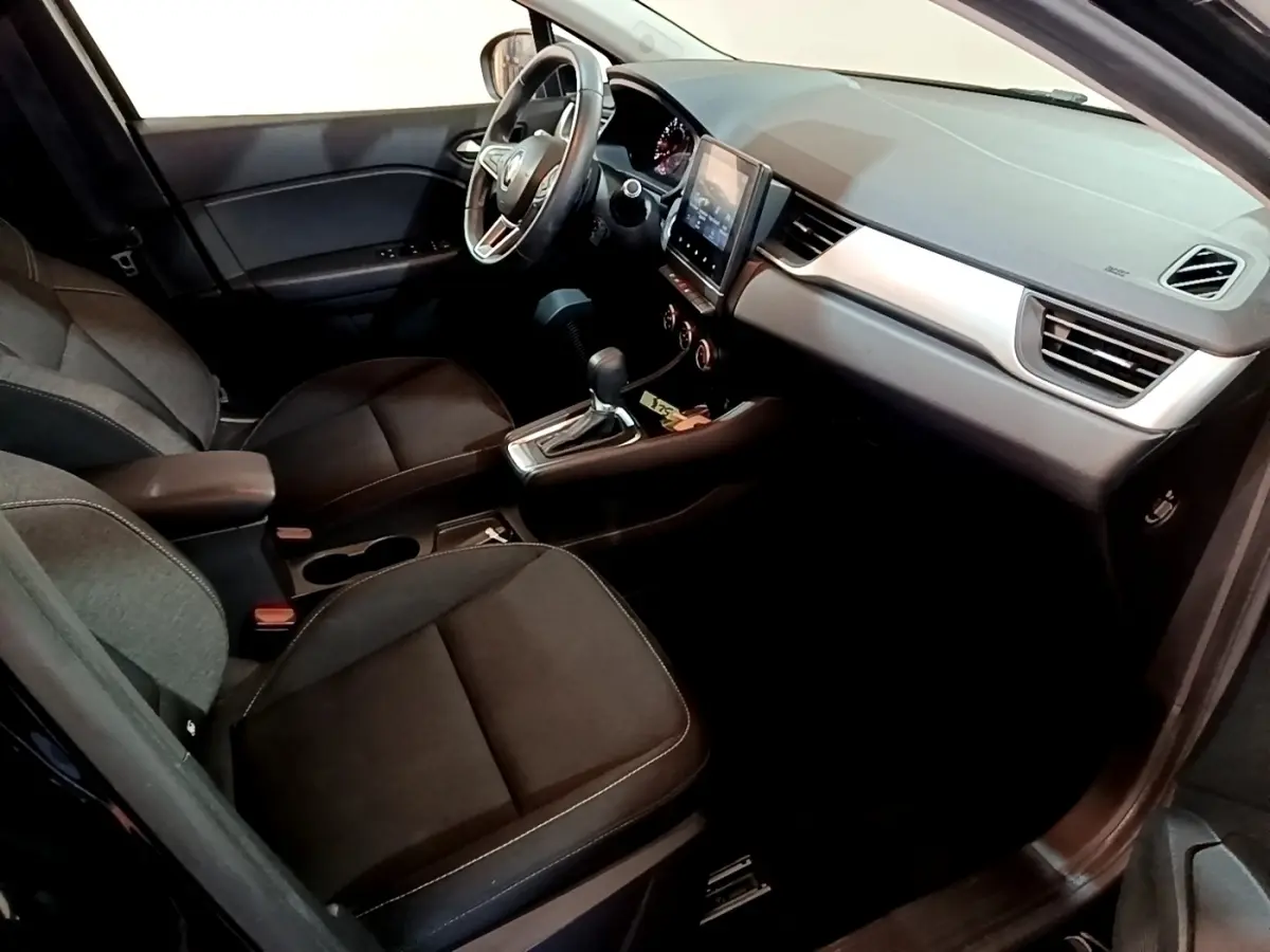 Vue intérieure côté conducteur du Renault Captur Business 2021, sièges noirs et tableau de bord avec écran tactile central.